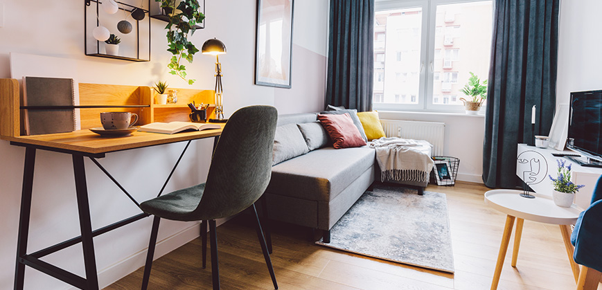 Modernes Wohnzimmer mit Schreibtisch Modernes Wohnzimmer mit Ecksofa, Schreibtisch und hübscher Deko