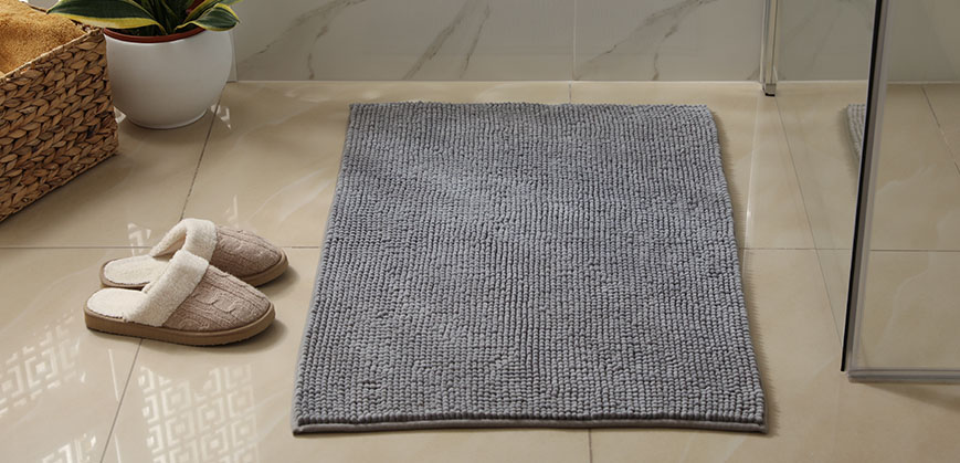 Graue Duschmatte und Pantoffeln in kleinem Badezimmer