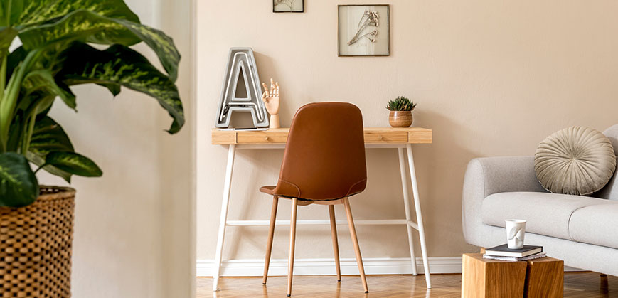 Auch in kleinen Wohnungen kann ein schöner Arbeitsbereich gestaltet werden, zum Beispiel im Wohnzimmer Kleiner Schreibtisch aus Holz und Stuhl vor einer rosa Wand