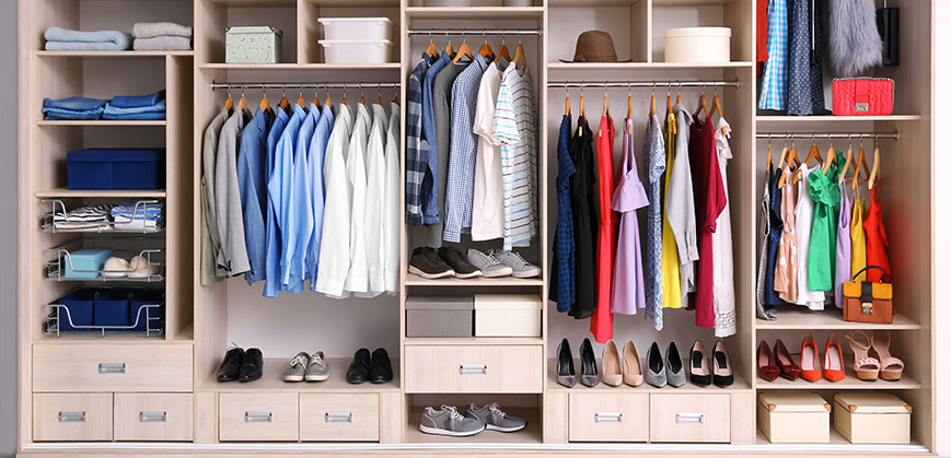 Großer sortierter Kleiderschrank mit viel bunter Kleidung
