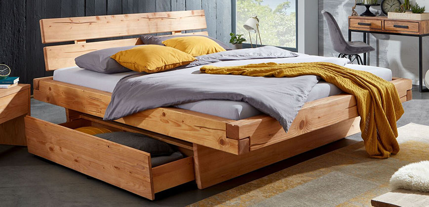 Doppelbett aus Holz mit grauer Bettwäsche dekoriert