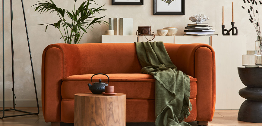 Rostrotes Sofa in modernem Wohnzimmer mit dunkelgrüner Decke und hölzernem Couchtisch