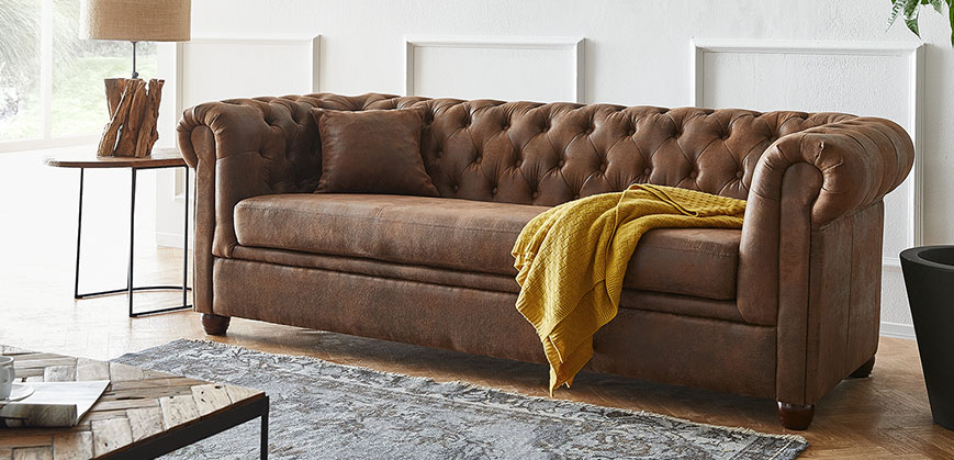 Vintage Chesterfield-Sofa mit Decke dekoriert