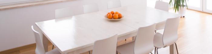Ein weißer ausziehbarer Esstisch, auf welchem Orangen stehen